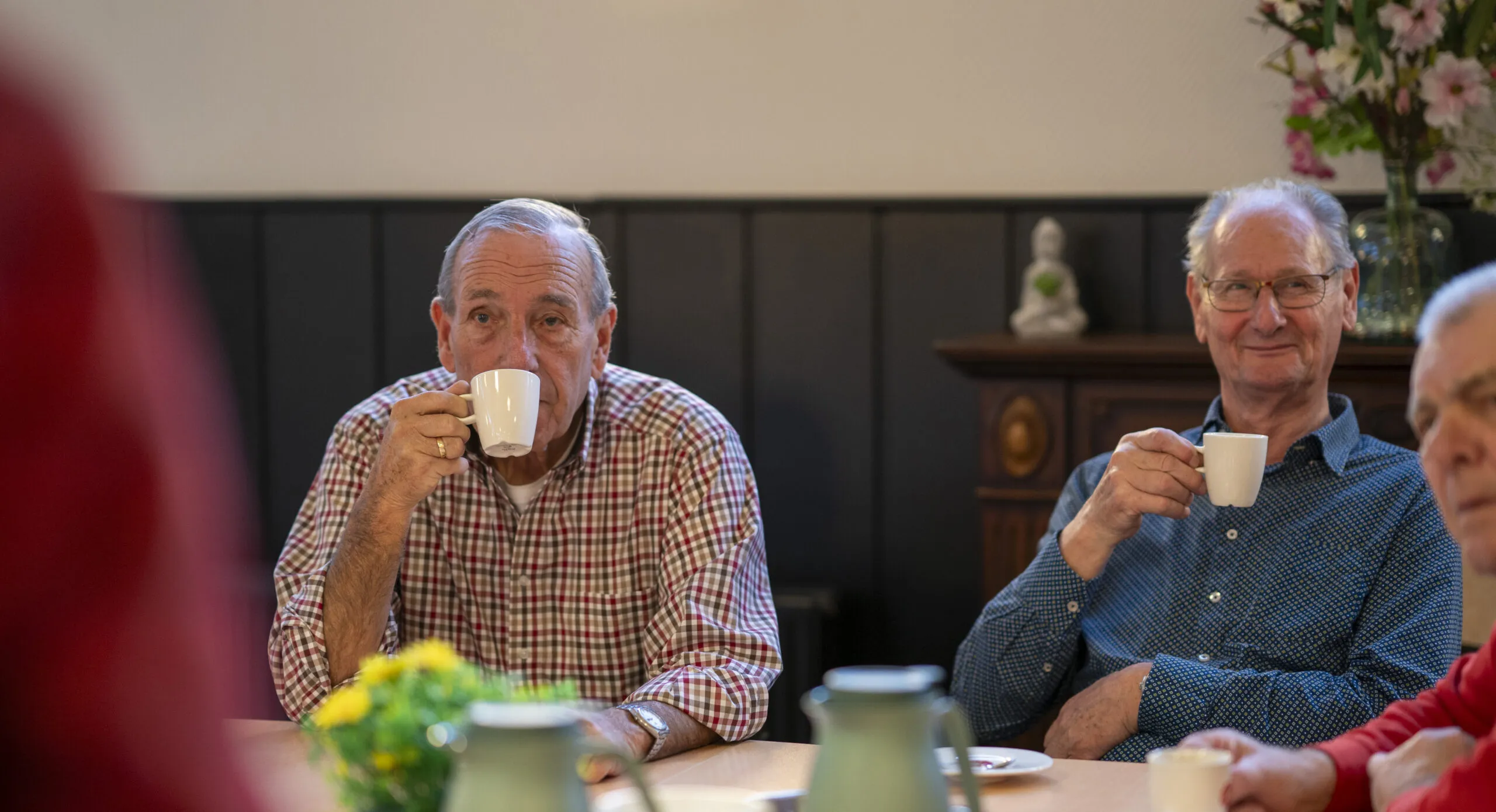 Mannen die een kopje koffie drinken en nakletsen over de valpreventieles in Vlaardingen